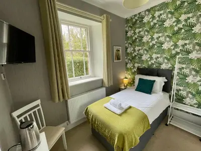 a small bedroom with a bed and a window at The Capsule Room at The Lairbeck in Keswick in Keswick
