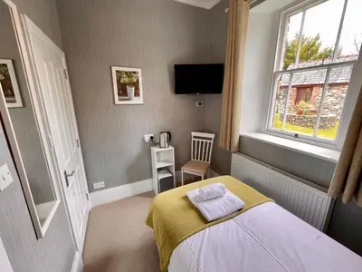 a small bedroom with a bed and a window at The Capsule Room at The Lairbeck in Keswick in Keswick