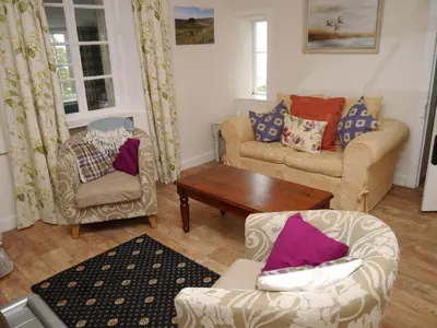 a living room with two chairs and a table at The Drovers Cabin in Kirkcudbright
