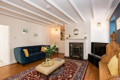 a living room with a blue couch and a fireplace at 118 High Street in Kirkcudbright