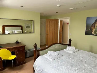 a bedroom with a bed and a desk and a mirror at The Wickerman Granary in Kirkcudbright