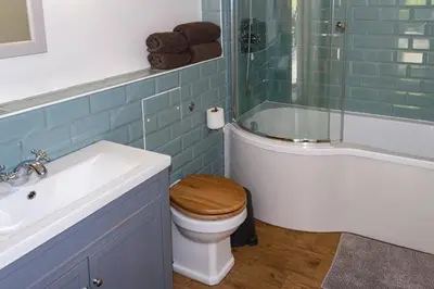 a bathroom with a toilet with a shower and a sink at Skerrow in New Galloway