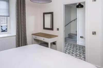 a bedroom with a bed and a mirror and a table at Stroan in New Galloway