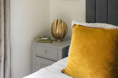 a yellow pillow sitting on a bed next to a nightstand at Bellfoot Rural Retreat and Hot Tub in Grasmere