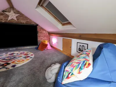 a living room with a blue couch and a flat screen tv at Lands Brow Lodge in Red Dial