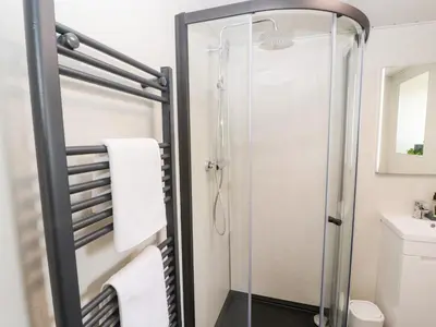 a shower with a glass door in a bathroom at Lands Brow Lodge in Red Dial