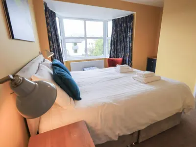 a bedroom with a large white bed with a window at Limhus House in Keswick