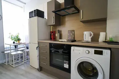 a kitchen with a washer and a refrigerator at 1 BDR Apt By Caledonia Luxe Stays Short Lets & Serviced Accommodation Lanark in Douglas