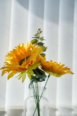 a vase filled with yellow flowers on a table at 1 BDR House By Caledonia Luxe Stays Short Lets & Serviced Accommodation Lanark in Douglas
