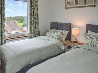two beds in a room with a window at Rivendell in Burgh by Sands