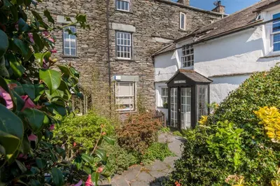 an old stone house with a garden in front of it at 2 Bed in Elterwater oc-gl004 in Chapel Stile