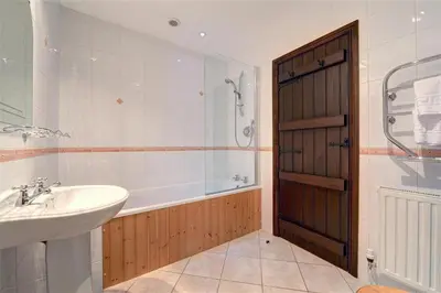 a bathroom with a tub and a sink and a shower at 2 Bed in Grasmere oc-gl007 in Grasmere