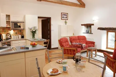 a kitchen and living room with red chairs and a table at 2 Bed in Grasmere oc-gl007 in Grasmere