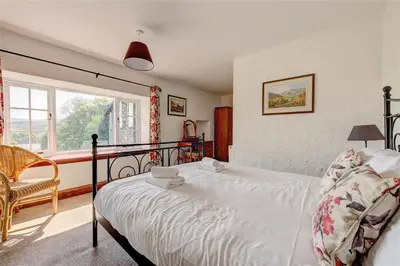 a bedroom with a bed and a chair and a window at 5 Bed in Grasmere oc-gl008 in Grasmere
