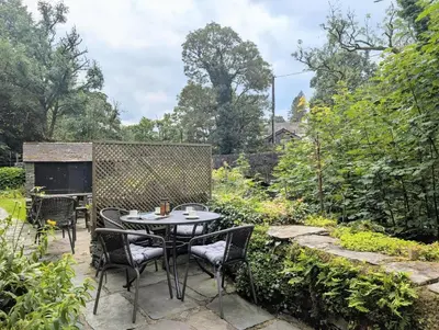 a patio with a table and chairs in a garden at 2 Bed in Elterwater oc-gl053 in Chapel Stile