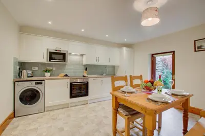 a kitchen with a table and a washing machine at 2 Bed in Grasmere oc-gl081 in Grasmere
