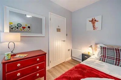 a small bedroom with a red dresser and a red drawer at 2 Bed in Chapel Stile oc-gl103 in Chapel Stile