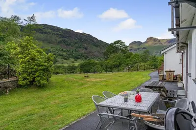 a table and chairs on the porch of a house at 2 Bed in Chapel Stile oc-gl103 in Chapel Stile