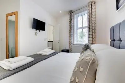 a bedroom with a bed and a tv on the wall at 2 Bed in Portinscale oc-gl129 in Portinscale