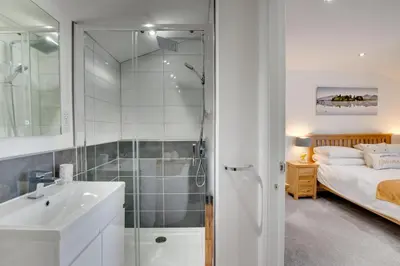 a bathroom with a shower and a sink and a bed at 2 Bed in Portinscale oc-gl129 in Portinscale