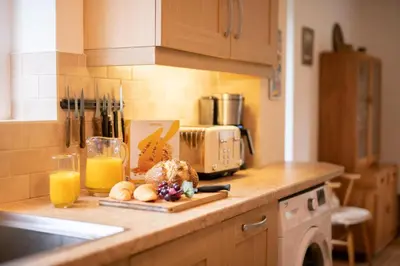 a kitchen counter with a plate of food and orange juice at 3 Bed in Grasmere oc-ld181 in Grasmere