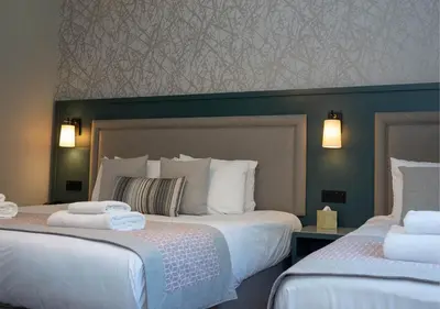 a hotel room with two beds with white sheets at Gretna Hall Hotel in Gretna Green