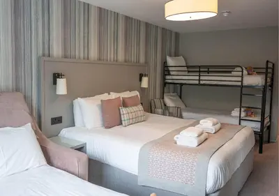 a bedroom with two beds and a bunk bed at Gretna Hall Hotel in Gretna Green