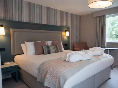 a hotel room with a large bed with towels on it at Gretna Hall Hotel in Gretna Green