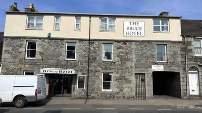 a white van parked in front of a building at The Bruce Hotel in Newton Stewart