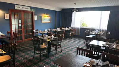 a dining room with tables and chairs in a restaurant at The Bruce Hotel in Newton Stewart