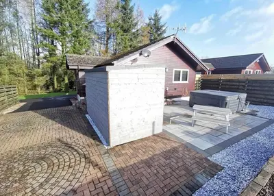 a backyard with a white shed and a grill at Cairnyard Lodges - Woodrow in Beeswing