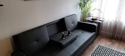a black couch in a living room with two bottles at Apartment - Sleeps 4 - Pet friendly - Parking in Troon