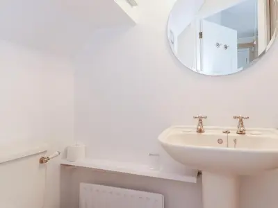 a white bathroom with a sink and a mirror at Oaklea in Keswick