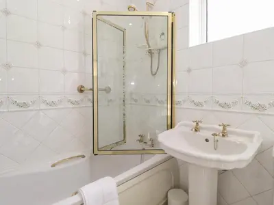 a white bathroom with a sink and a shower at Oaklea in Keswick