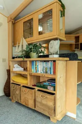 a wooden book shelf with books on it at Treetops in Lamplugh