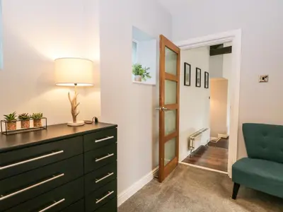 a bedroom with a dresser and a blue chair at 8A Corkickle in Whitehaven