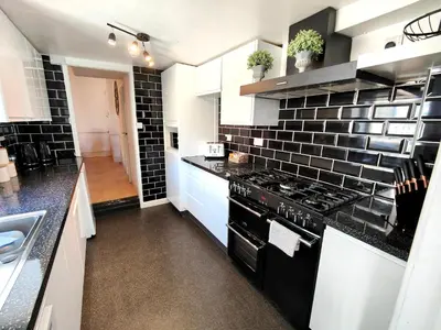 a kitchen with black and white tile on the wall at Squirrel Lodge in Keswick