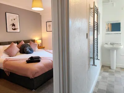 a bedroom with a bed with a person laying on it at Squirrel Lodge in Keswick