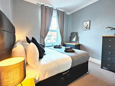 a bedroom with a large bed and a window at Squirrel Lodge in Keswick
