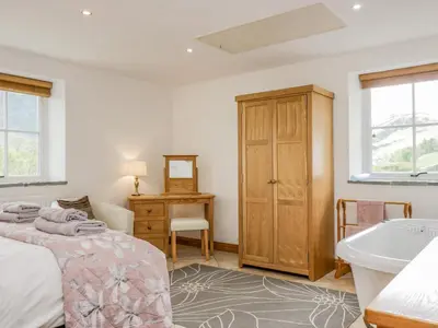 a bedroom with a bed and a sink at Shundraw Cottage in Keswick
