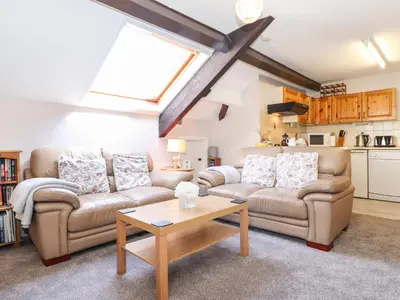 a living room with two couches and a table at Bakers Yard Cottage in Ambleside