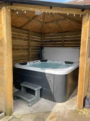 a large hot tub in a wooden structure at Lovely 2 bed apartment with hot tub log burner and off street parking in Dumfries