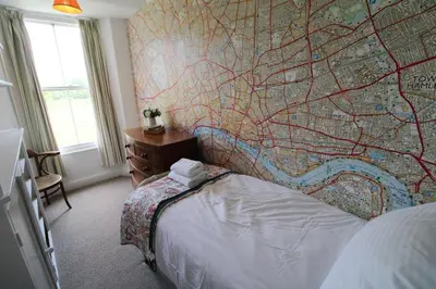 a bedroom with a large map on the wall at Little Parrock, Grasmere nestled at the foot of Helm Crag with walks from the door in Grasmere