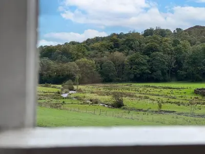 a view of a field from a window at Little Parrock, Grasmere nestled at the foot of Helm Crag with walks from the door in Grasmere