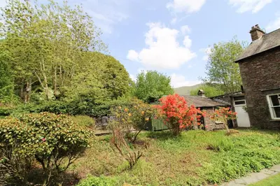 a garden in front of an old brick house at Little Parrock, Grasmere nestled at the foot of Helm Crag with walks from the door in Grasmere