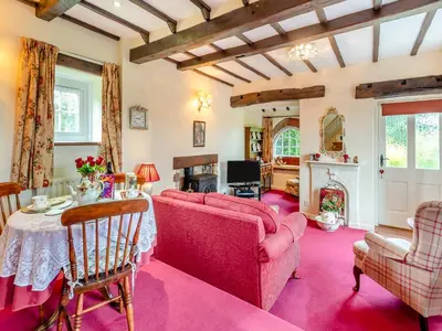a living room with pink furniture and a fireplace at Rose Cottage - Lpd in Ireby