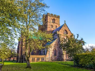 an old church with a tower on a green field at The Coach House in Wetheral