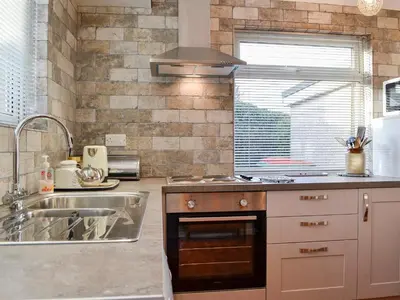 a kitchen with a sink and a stove top oven at Briar Bank Bungalow in Cockermouth