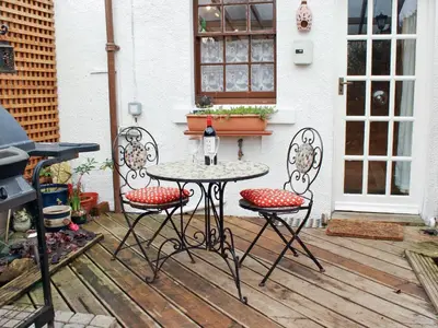a table and two chairs on a wooden deck at Tanner's Cottage in Cockermouth