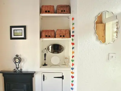 a bathroom with a mirror and a white refrigerator at Tanner's Cottage in Cockermouth